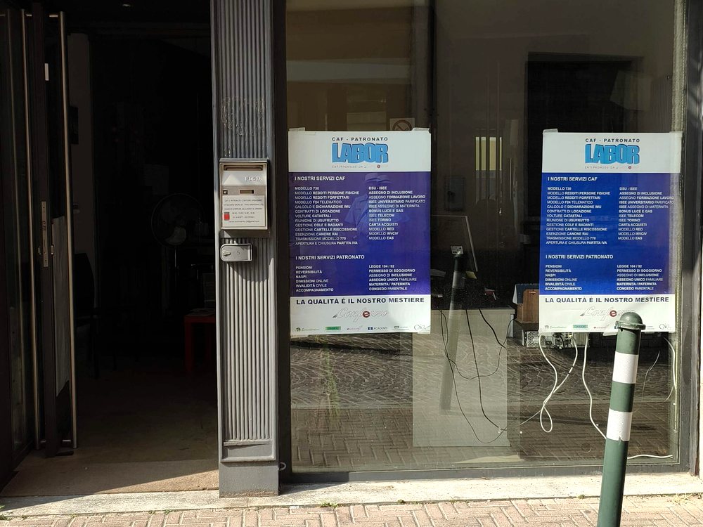 La vetrina del CAF Confeuro in Via Nazario Sauro 25 a Orbassano, con le locandine CAF - Patronato Labor